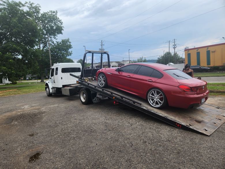 Flatbed transport of a red BMW coupe